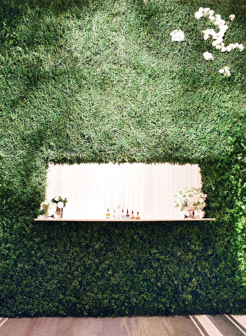 Greenery Wall of Wedding Bar
Photography: Jose Villa Photography
Read More:
http://www.insideweddings.com/weddings/glamorous-sophisticated-garden-themed-ballroom-wedding-in-chicago/905/ Wedding bar with alcohol displayed and flower arrangements inside hedge wall at wedding