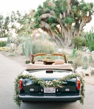 Vintage Getaway Car
Photography: Koman Photography
Read More:
http://www.insideweddings.com/weddings/boho-chic-inspirational-wedding-with-desert-details-and-soft-colors/1137/ 1980s rolls royce convertible getaway car with garland of greenery and succulents