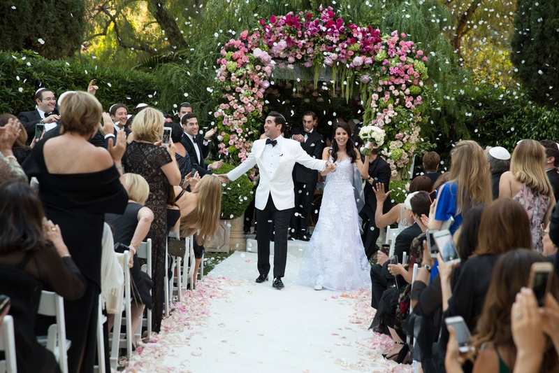 Flower Cannon at Outdoor Wedding
Photography: Jay Lawrence Goldman Photography
Read More:
http://www.insideweddings.com/weddings/outdoor-ceremony-ballroom-reception-with-pink-flowers-greenery/1135/ Bride and groom walking up aisle as husband and wife flower petal cannon going off white petals