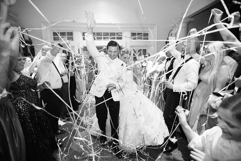 Confetti Grand Exit After Reception
Photography: Sarah Kate, Photographer
Read More:
http://www.insideweddings.com/weddings/outdoor-fall-ceremony-opulent-tented-reception-in-dallas-texas/1022/ Black and white photo of bride and groom leaving wedding through tunnel of friends with confetti