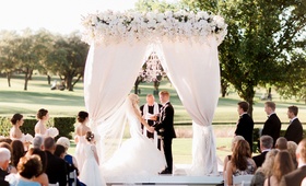 Guests Watching Couple Say "I Do"
Photography: Jennefer Wilson Photography
Read More:
http://www.insideweddings.com/weddings/gorgeous-dallas-wedding-with-outdoor-ceremony-ballroom-reception/998/ Bride in wedding dress black tux on groom chandelier outdoor wedding ceremony all white decor flower
