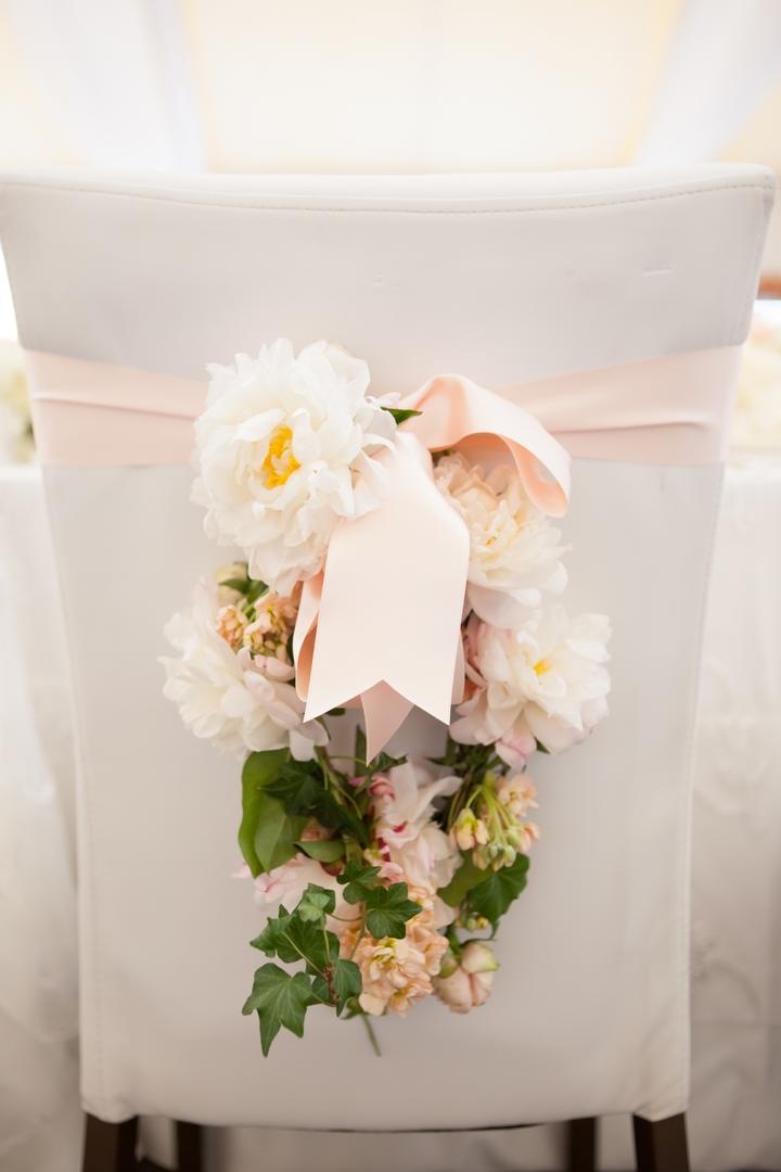 Chair Floral Arrangement
Photography: Carrie Rodman Photography
Read More:
http://www.insideweddings.com/weddings/new-england-summer-wedding-by-the-seashore/429/ White and pink flowers hanging from pink ribbon on chair