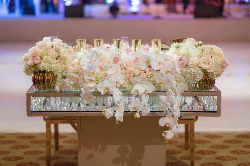 Sweetheart Table with Crystal Details
Photography: The Yodsukars
Read More:
http://www.insideweddings.com/weddings/glam-10th-wedding-anniversary-party-vow-renewal-in-california/917/ Sweetheart table with glass layers crystals in between orchid rose flower arrangement candles gold