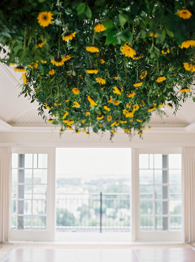 Sunflowers Over Dance Floor
Photography: Branco Prata
Read More:
http://www.insideweddings.com/weddings/chic-destination-wedding-with-california-style-in-washington-dc/1042/ Wedding reception in Washington DC sunflowers and greenery leaves overhead above dance floor