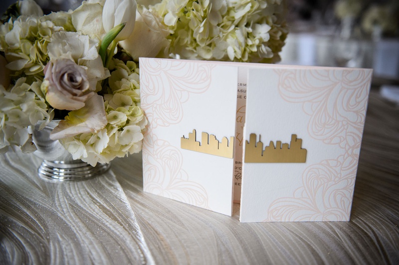 Blush Design %26 Gold Skyline on Invite
Photography: Chris Bailey Photography
Read More:
http://www.insideweddings.com/weddings/modern-elegant-ballroom-wedding-with-white-flowers-in-houston/1246/ wedding invitation booklet with gold skyline cutout houston texas pink floral motif on folds
