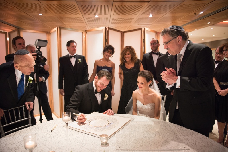 Bride and Groom Sign Their Ketubah
Photography: Ira Lippke Studios
Read More:
http://www.insideweddings.com/weddings/chic-classic-new-york-city-wedding-with-personal-touches/783/ a jewish bride and groom signing the ketubah with friends and family around before ceremony