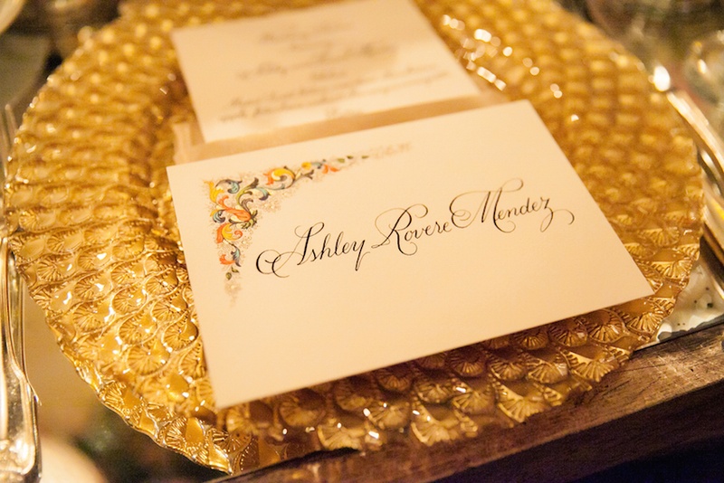 Calligraphy Escort Card on Gold Charger
Photography: Michael Carr Photography
Read More:
http://www.insideweddings.com/weddings/traditional-church-ceremony-forest-inspired-reception-in-houston/695/ Gold charger plate with texture and unique escort card