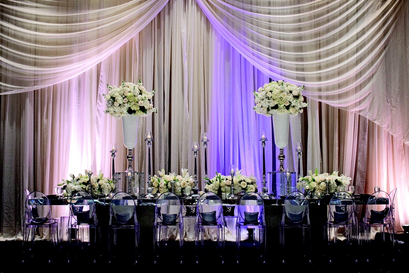 Glamorous Head Table
Photography: Collins Metu Photography
Read More:
http://www.insideweddings.com/weddings/sarita-minor-and-jarett-dillard/432/ Mirror table with clear chairs in front of drapery