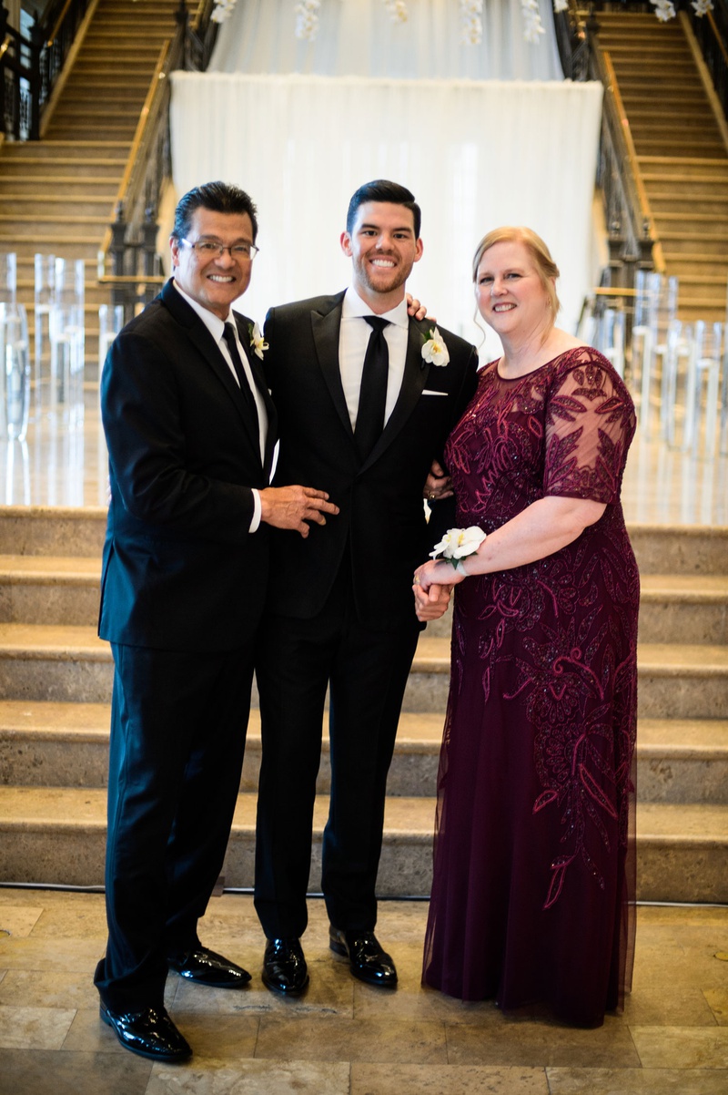 Mother of Groom with Corsage
Photography: Chris Bailey Photography
Read More:
http://www.insideweddings.com/weddings/modern-elegant-ballroom-wedding-with-white-flowers-in-houston/1246/ groom with father and mother in burgundy dress sheer detail beading white flower corsage on wrist