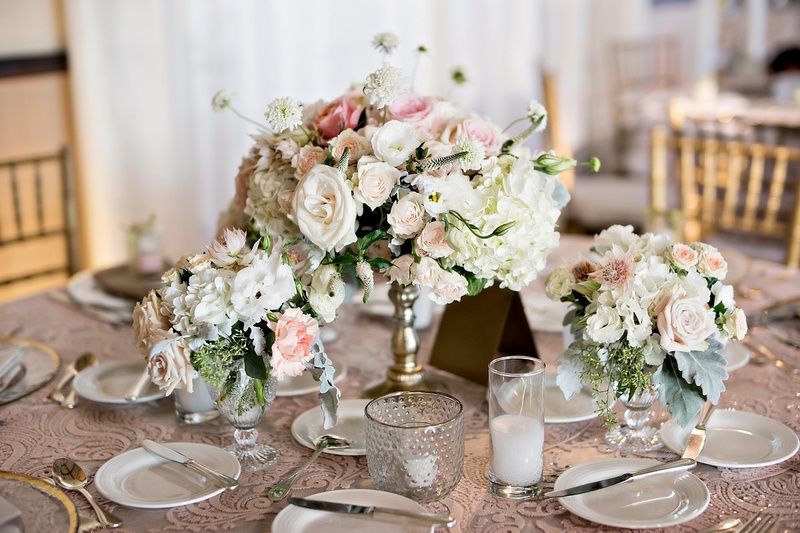 Smaller Trio of Centerpieces
Photography: Laurie Bailey Photography
Read More:
http://www.insideweddings.com/weddings/oceanfront-wedding-ceremony-classic-romantic-ballroom-reception/854/ lower gold pedestal arrangement surrounded by candles,garden roses, hydrangea, exotic orchard blooms