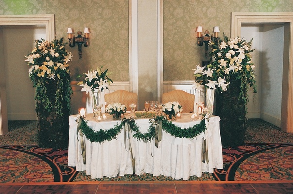 Beach Sand Hotel Ballroom Sweetheart Table With Green Garlands Beach Sand Hotel Ballroom Sweetheart Table With Green Garlands