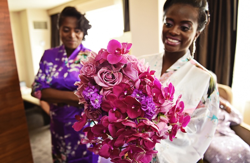 Vibrant Bridal Bouquet
Photography: Carasco Photography
Read More:
http://www.insideweddings.com/weddings/city-wedding-at-chicago-planetarium-with-purple-yellow-palette/688/ Bride in robe holds bouquet of magenta orchids, light purple roses