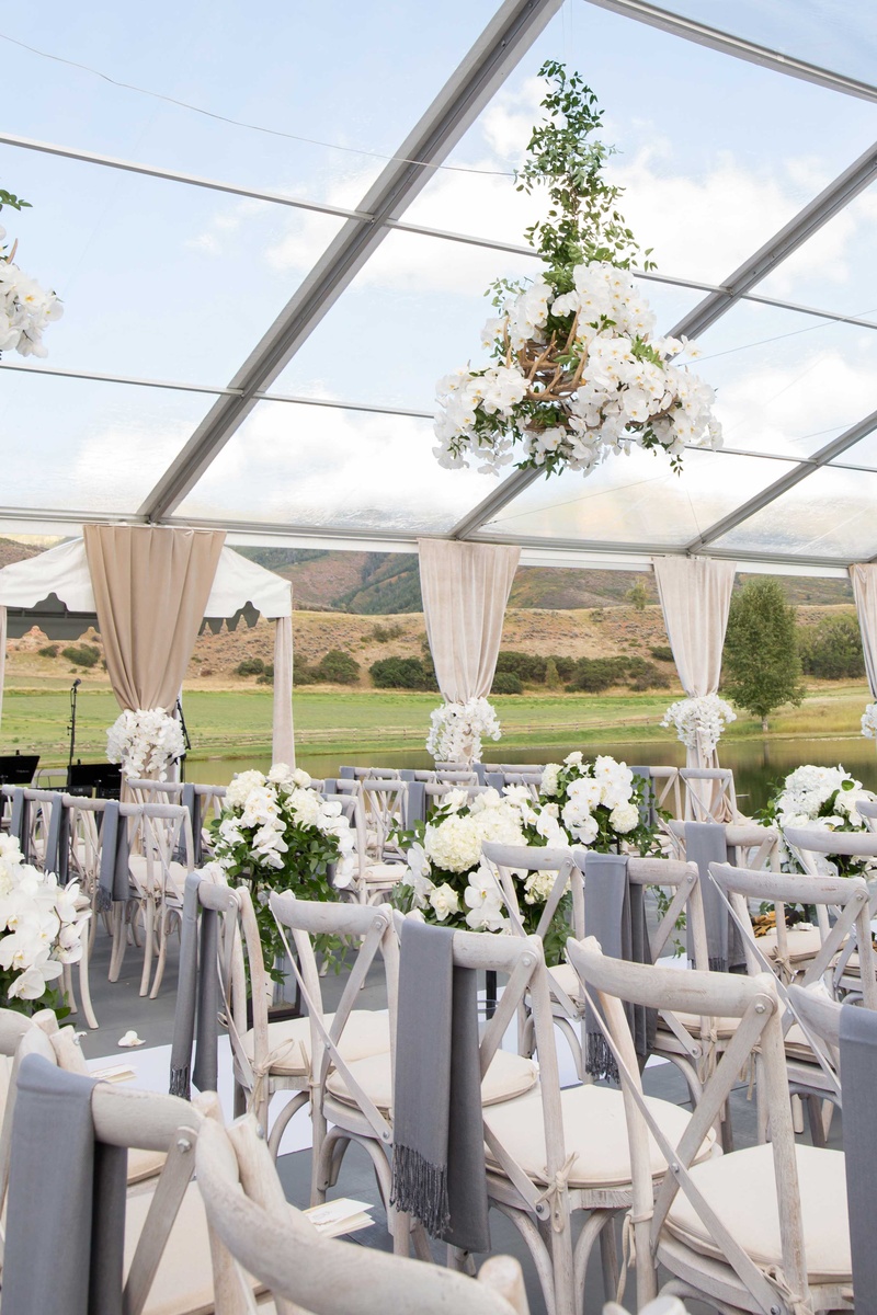 Grey Pashminas Over Wood Chairs
Photography: Perez Photography
Read More:
http://www.insideweddings.com/weddings/incredible-tented-ceremony-barn-reception-at-ranch-in-aspen/860/ Whitewash wood chairs with grey blankets on back antler greenery flower chandelier ranch venue tent