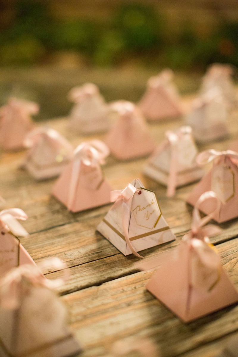 Pyramid Favor Boxes with Ribbons
Photography: Ashley Paige Photography
Read More:
http://www.insideweddings.com/weddings/elegant-outdoor-fall-wedding-at-a-rustic-chic-venue-in-malibu/1244/ wedding favor ideas pyramid boxes with gold pink decor thank you note ribbon jordan almonds