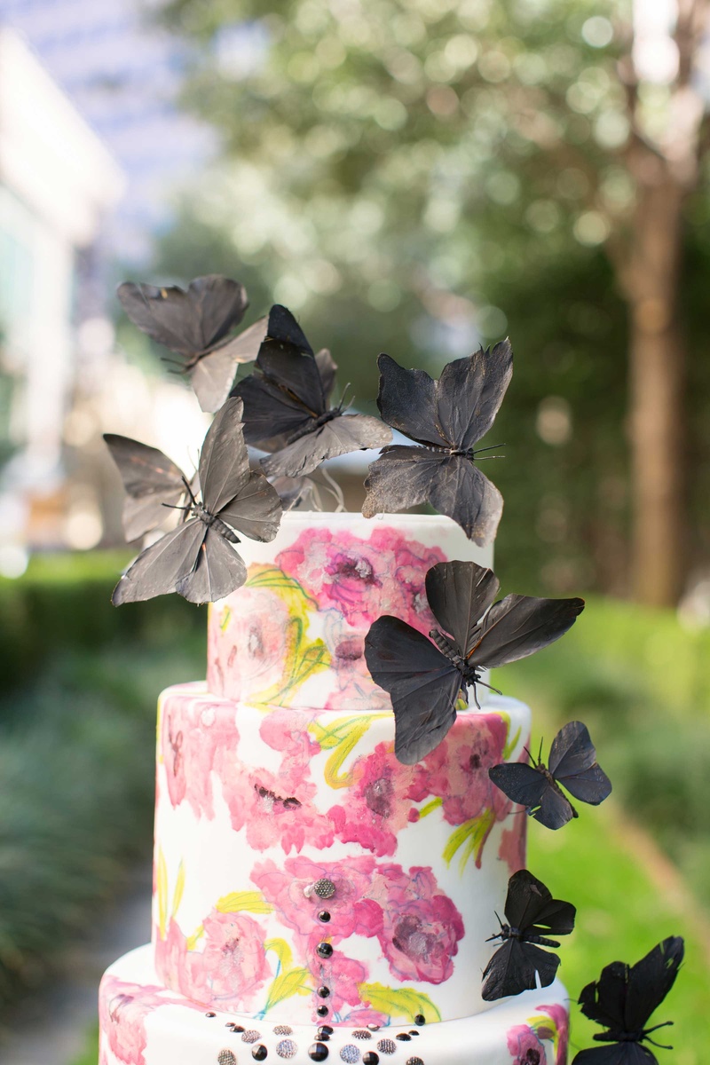 White Cake with Pink Flower Design and Black Butterflies
Photography: Thisbe Grace Photography
Read More:
http://www.insideweddings.com/weddings/dramatic-wedding-shoot-inspired-by-alexander-mcqueen-chanel/749/ white cake with pink flower design and black jewels and black butterflies on top