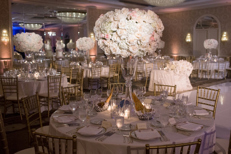 Classic Centerpiece of Pale Roses
Photography: Duke Photography
Read More:
http://www.insideweddings.com/weddings/jewish-ceremony-classic-ballroom-reception-in-beverly-hills/922/ ivory and blush roses held by crystal stand, gold chiavari chairs