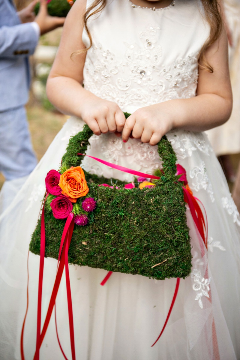 Moss Flower Girl Purse
Photography: Laurie Bailey Photography
Read More:
http://www.insideweddings.com/weddings/outdoor-jewish-ceremony-reception-with-colorful-bohemian-decor/1330/ wedding ceremony flower girl in ball gown with mosss handbag purse and basket with pink ribbon