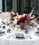 Edgy Centerpiece with Roses and Pampas Grass
Photography: Jessica Claire Photography
Read More:
http://www.insideweddings.com/weddings/unique-chic-bridal-shower-with-dark-and-moody-color-scheme/1335/ round table with centerpiece of burgundy and mauve roses with pampas grass