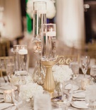 Floating Candle on Gold Stand
Photography: Shaun Menary Photography
Read More:
http://www.insideweddings.com/weddings/multicultural-wedding-with-a-winter-wonderland-theme-in-dallas/1126/ Wedding reception table low arrangement cluster of white flowers and candles