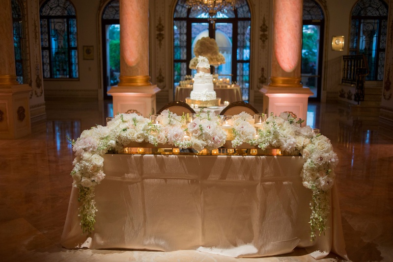 Floral Runner on Sweetheart Table
Photography: Nancy Cohn Photography
Read More:
http://www.insideweddings.com/weddings/destination-wedding-with-white-gold-color-palette-in-palm-beach/1028/ Wedding reception sweetheart table with white flower garland runner and gold linen