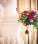Bride Holding Red Rose Bouquet
Photography: Juan Carlos Tapia Photography
Read More:
http://www.insideweddings.com/weddings/rustic-destination-wedding-with-touching-details-on-beach-in-mexico/801/ a bride holding a bouquet of red roses and leafy greenery