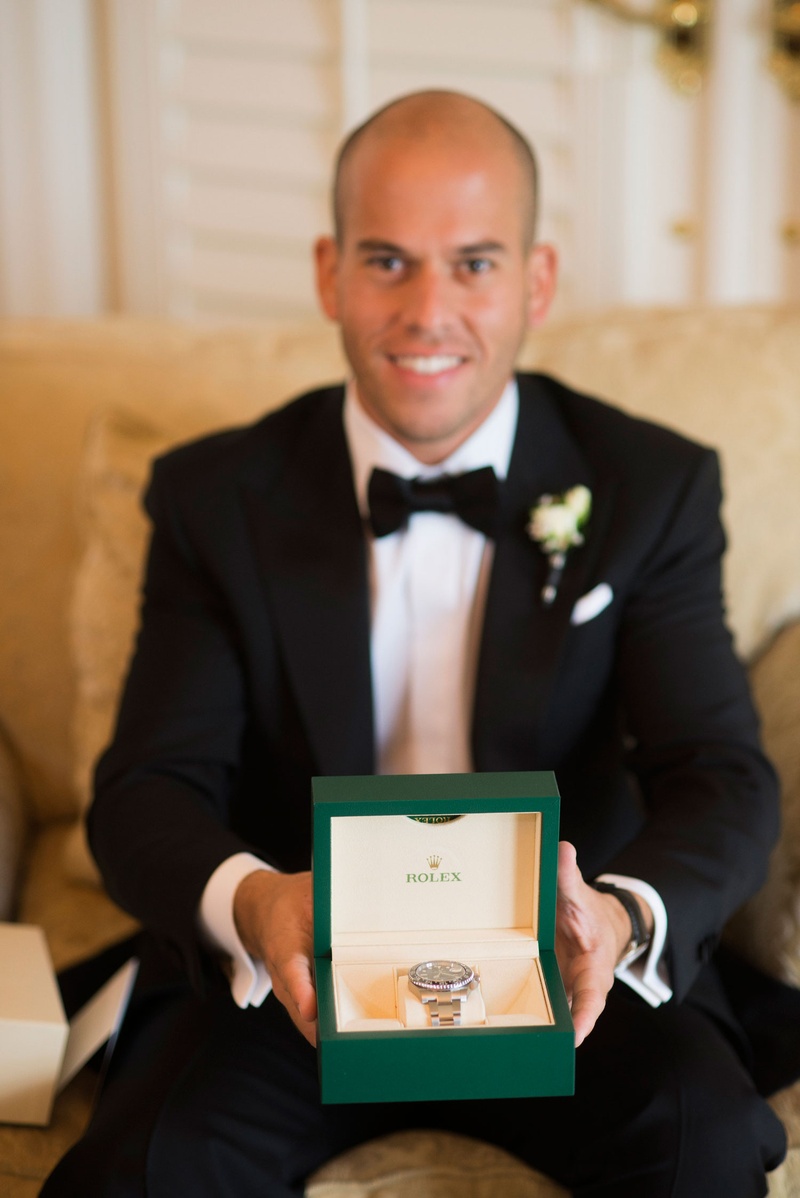 Groom with Rolex Gift
Photography: Nancy Cohn Photography
Read More:
http://www.insideweddings.com/weddings/destination-wedding-with-white-gold-color-palette-in-palm-beach/1028/ Groom in tuxedo holding Rolex watch in green box platinum