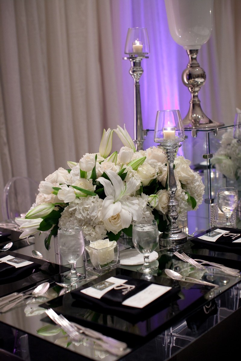 White Wedding Centerpiece
Photography: Collins Metu Photography
Read More:
http://www.insideweddings.com/weddings/sarita-minor-and-jarett-dillard/432/ White lily, tulip, rose, and hydrangea flowers on mirror table
