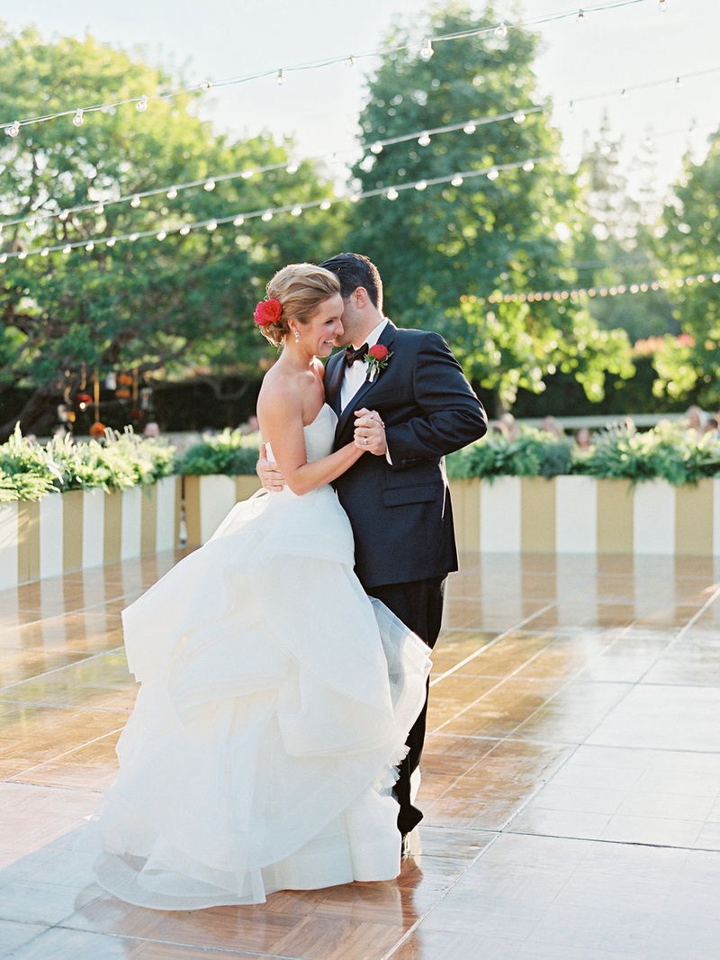 Bride %26 Groom's First Dance Under Twinkle Lights
Photography: Ryan Ray Photography
Read More:
http://www.insideweddings.com/weddings/outdoor-wedding-with-vibrant-pink-orange-decor-in-california/723/ Bride in Vera Wang wedding dress with red flower in hair dances with groom on large dance floor