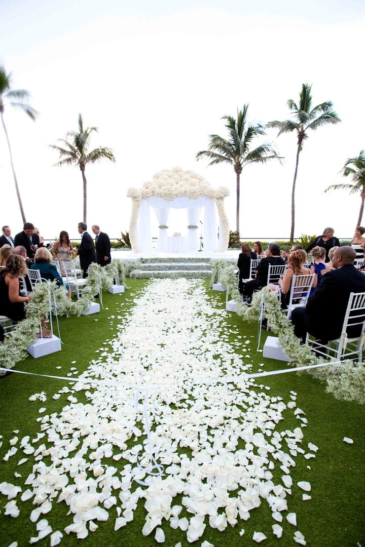 Elegant Oceanfront Ceremony
Photography: Lauren Ross Photography %26 Nancy Cohn Photography
Read More:
http://www.insideweddings.com/weddings/sophisticated-breakers-wedding-with-pink-florals/335/ White flower petals on grass aisle lead to white flower chuppah