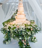 Rose Gold Wedding Cake
Photography: Michael Carr Photography
Read More:
http://www.insideweddings.com/weddings/glamorous-outdoor-wedding-with-rustic-rose-gold-details-in-texas/842/ Tall white wedding cake with rose gold ribbon fresh flowers flower cake stand display