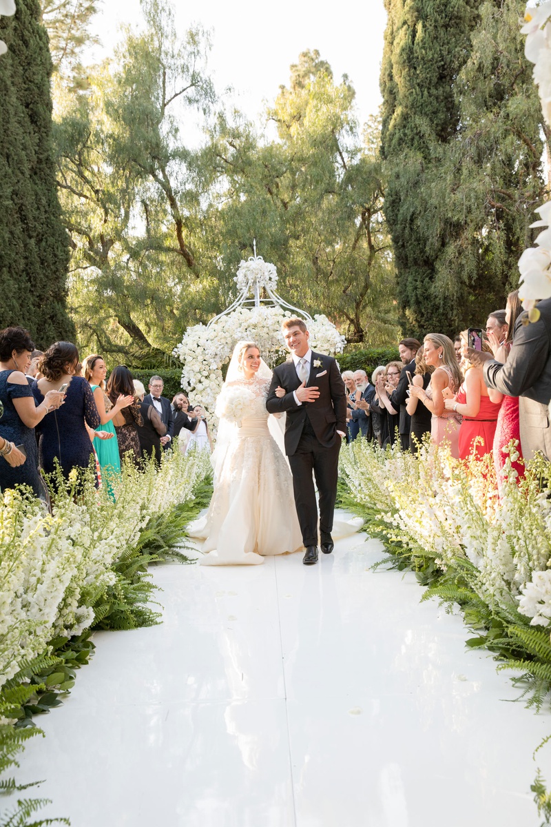 Guests Cheer for Beverly Hills Couple
Photography: Duke Photography
Read More:
http://www.insideweddings.com/weddings/luxurious-alfresco-ceremony-ballroom-reception-in-beverly-hills/1161/ Beverly HIlls Hotel wedding bride and groom walking up aisle stock and ferns along aisle white arch