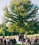 Countryside Outdoor Wedding Ceremony
Photography: Adam Barnes
Read More:
http://www.insideweddings.com/weddings/elegant-real-wedding-at-a-charming-resort-in-the-countryside/1141/ Bride and groom at outdoor wedding ceremony guests seated in the round under tall tree