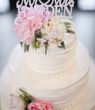 White Wedding Cake with Custom Topper
Photography: Clane Gessel Photography
Read More:
http://www.insideweddings.com/weddings/rustic-inspired-summer-wedding-at-a-vineyard-in-northern-california/651/ Wedding cake with fresh pink and white peonies, greenery, and cake topper with couple's last name