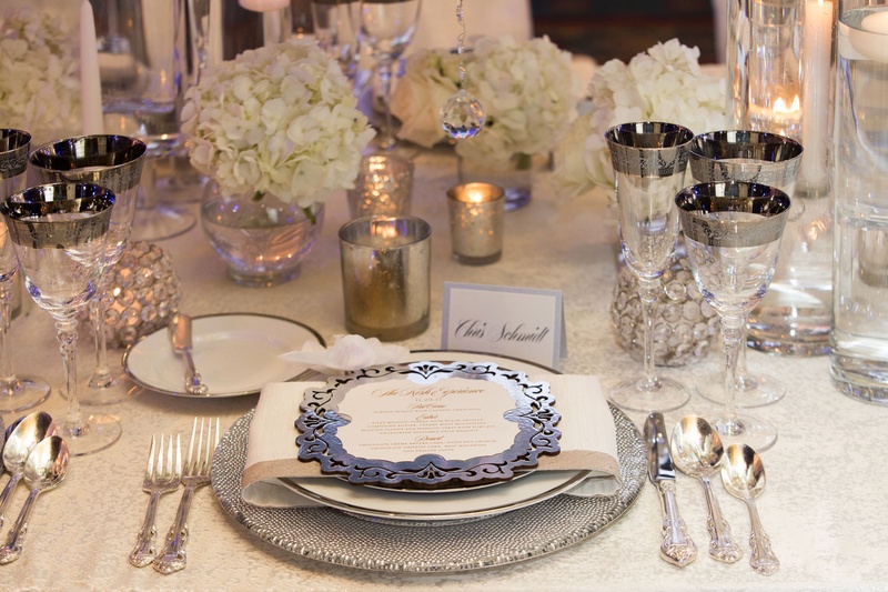 Silver Décor on Ivory Table
Photography: Collin Pierson Photography
Read More:
http://www.insideweddings.com/weddings/winter-wedding-inspirational-shoot-with-opulent-frosted-decor/1108/ Wedding reception table silver charger plate and menu card rimmed glassware white hydrangea candles
