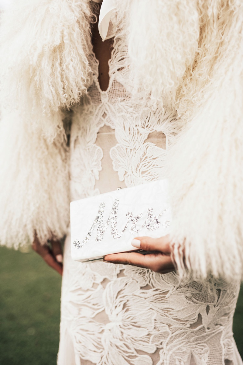 Mother-of-Pearl "Mrs." Clutch
Photography: Sam %26 Sola Lee Photography
Read More:
http://www.insideweddings.com/weddings/modern-outdoor-ceremony-tent-reception-in-seattle-on-puget-sound/1309/ bride in wedding dress with fur wrap holding mother of pearl silver mrs edie parker wedding purse