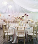 French-Theme Pastel Wedding Reception
Photography: Caroline Tran
Read More:
http://www.insideweddings.com/weddings/magical-garden-ceremony-tented-reception-with-chic-french-theme/733/ Round wedding table with gold chairs, light blue napkins, and pastel tall flower arrangements