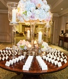 Towering Centerpiece at Escort Card Table
Photography: KingenSmith
Read More:
http://www.insideweddings.com/weddings/modern-wedding-with-soft-color-palette-and-personalized-details/792/ large pastel floral centerpiece with candles at escort card table