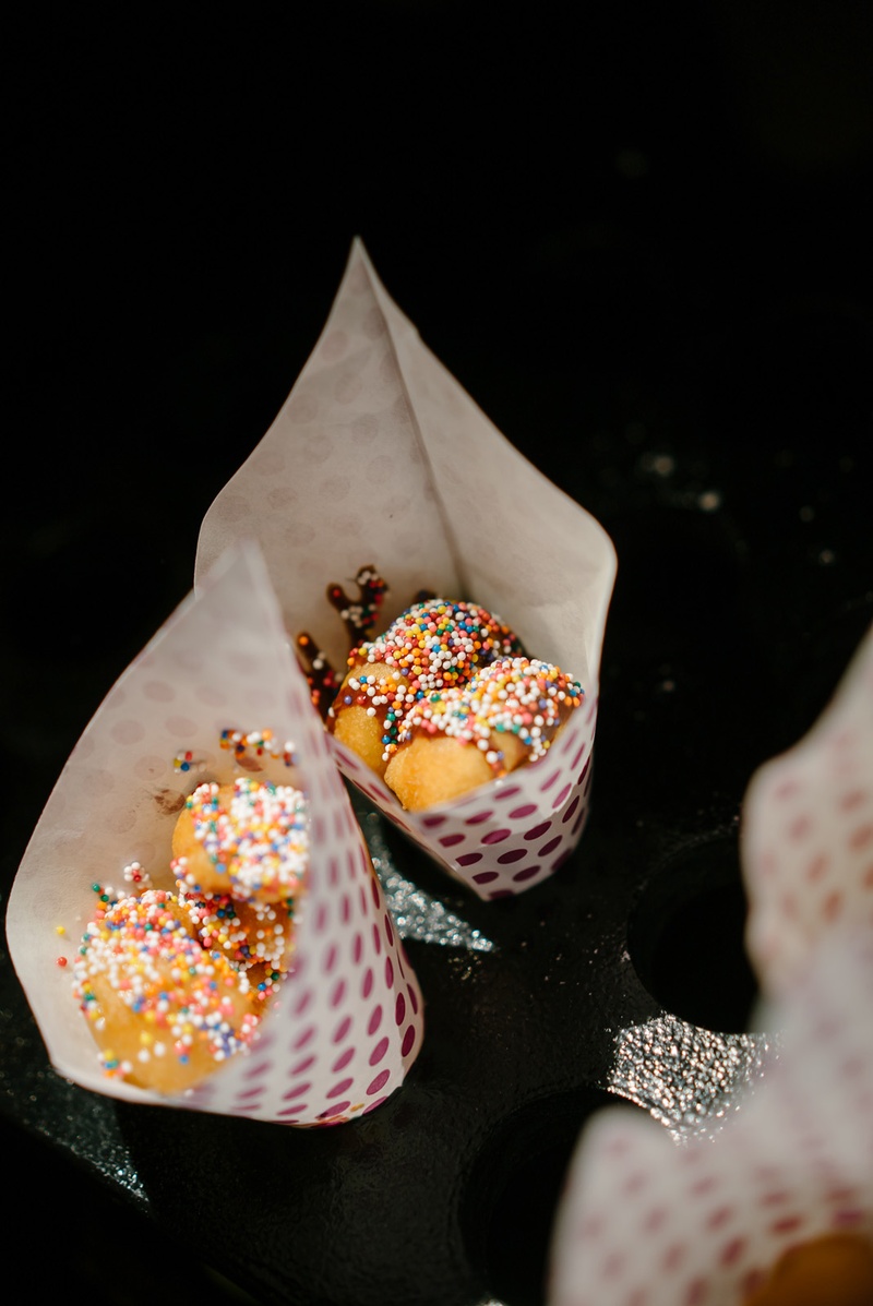 Sprinkled Donuts in Paper Cones
Photography: Karlisch Photography
Read More:
http://www.insideweddings.com/weddings/modern-rustic-wedding-full-of-flowers-and-geometric-details/906/ donut truck wedding desserts sprinkled donuts in paper cones