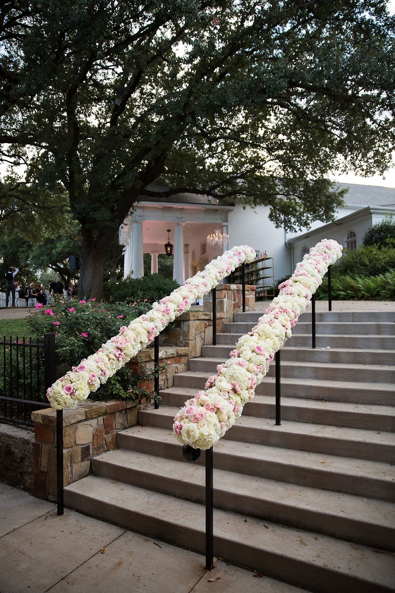 White %26 Pink Flowers Along Stairwell
Photography: Sarah Kate, Photographer
Read More:
http://www.insideweddings.com/weddings/outdoor-fall-ceremony-opulent-tented-reception-in-dallas-texas/1022/ White and pink rose flowers on hand rail going up stairs at outdoor wedding venue