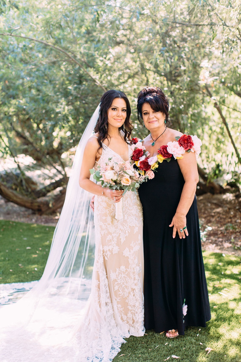 Mother-of-Bride in Gown with Floral Neckline
Photography: Ashley Paige Photography
Read More:
http://www.insideweddings.com/weddings/elegant-outdoor-fall-wedding-at-a-rustic-chic-venue-in-malibu/1244/ bride in calla blanche wedding dress with mother in black dress with faux flower neckline pink red