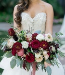 Lush Bouquet with Deep Red Florals
Photography: David Manning Photographer
Read More:
http://www.insideweddings.com/weddings/interfaith-ceremony-tented-reception-with-romantic-color-palette/885/ wide bridal bouquet with scarlet dahlias, blush and ivory roses, and eucalyptus
