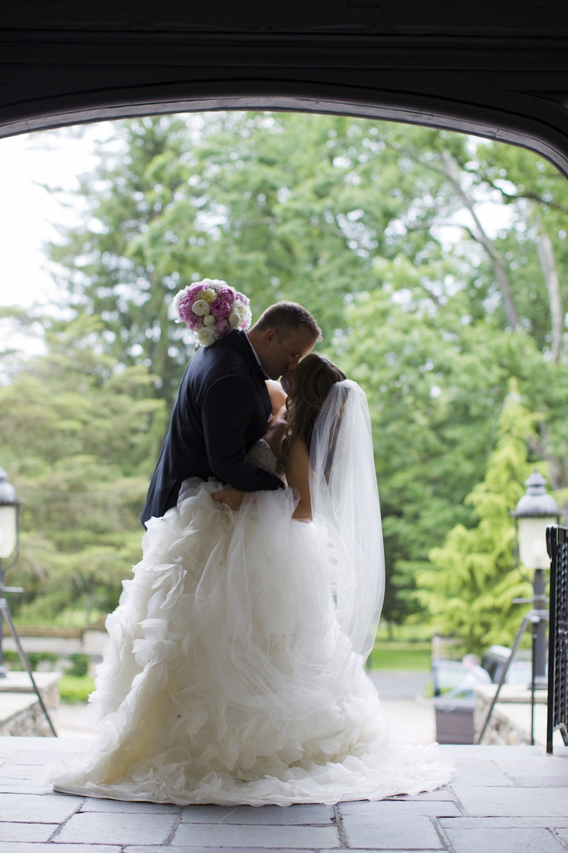 Groom Kisses Bride in Doorway
Photography: Images by Berit, Inc.
Read More:
http://www.insideweddings.com/weddings/wedding-with-purple-modern-details-at-a-chateau-in-new-jersey/693/ Bride in strapless Lazaro dress with full ruffled skirt, veil, kisses groom in black tuxedo