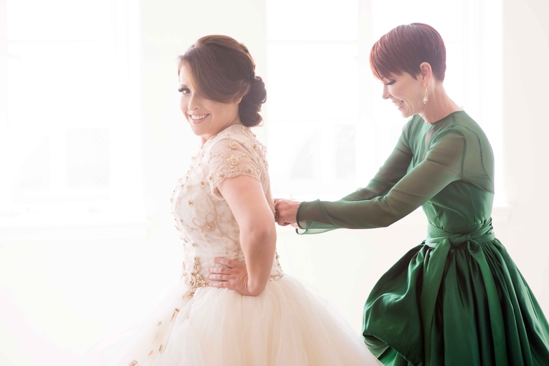Mother of Bride in Long Sleeve Green Gown
Photography: KLK Photography
Read More:
http://www.insideweddings.com/weddings/greek-orthodox-church-ceremony-glamorous-purple-gold-reception/730/ Mother of bride helping daughter put on wedding dress in designer green dress with long sleeves