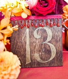 Table Number
Photography: Mi Belle Photographers
Read More:
http://www.insideweddings.com/weddings/elegant-red-gold-wedding-in-malibu-california/366/ Wedding reception table number on a wood board decorated with red ribbon and beads