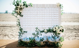 Beachside Escort Card Display
Photography: Yvette Roman Photography
Read More:
http://www.insideweddings.com/weddings/all-white-wedding-at-a-beach-club-in-santa-monica-california/706/ Beachside wedding reception with clapboard place card display, greenery, white roses, flip-flops