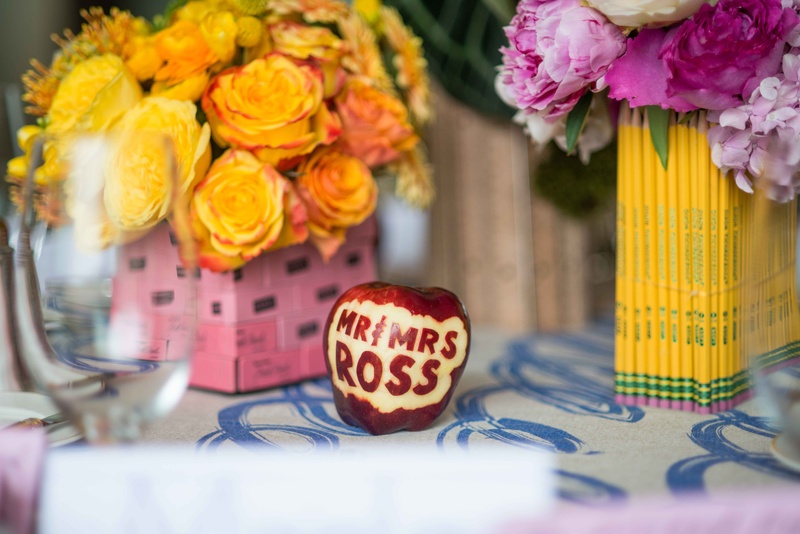 "Mr. %26 Mrs. Ross" Red Apple Décor
Photography: John %26 Joseph Photography Inc.
Read More:
http://www.insideweddings.com/weddings/a-school-themed-bridal-shower-in-beverly-hills-for-a-teacher/890/ Pink eraser and pencil vases yellow pink flowers bridal shower school theme carved apple