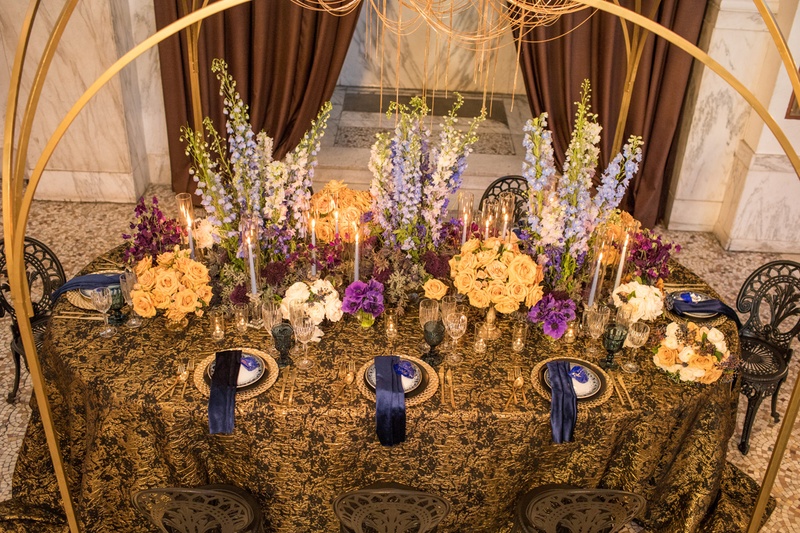 Vibrant Florals on Dramatic Linens
Photography: Duke Photography
Read More:
http://www.insideweddings.com/weddings/dramatic-tablescape-at-launch-party-for-luxe-linens-newest-line/987/ wedding styled shoot, blue delphiniums, light orange roses, purple sweet peas, black and gold linens