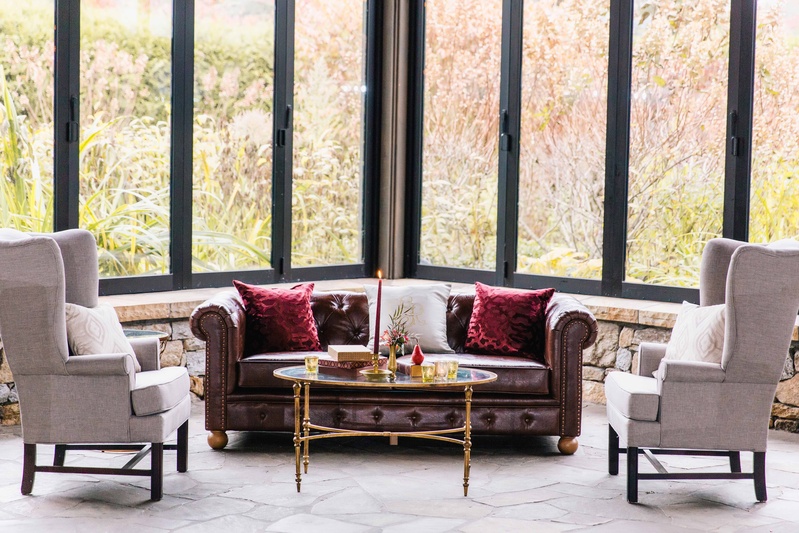 Open Indoor Space with Furniture
Photography: Vue Photography
Read More:
http://www.insideweddings.com/weddings/baroque-autumn-wedding-with-deep-wine-tones-in-north-carolina/770/ open air space with dark and light colored furniture and tall windows looking outside