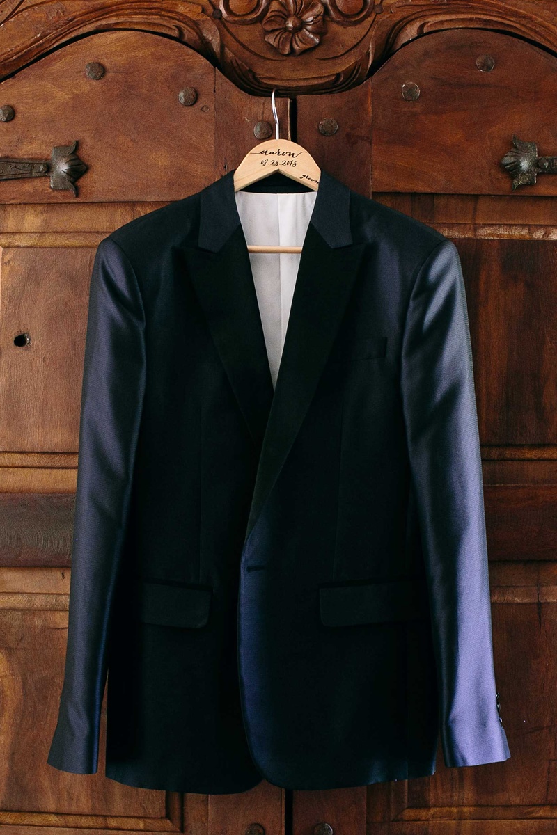Groom's Dark Blue Tuxedo Jacket
Photography: Callaway Gable
Read More:
http://www.insideweddings.com/weddings/alfresco-summer-wedding-with-lush-foliage-accents-in-california/805/ a grooms dark blue tuxedo jacket hanging up before ceremony