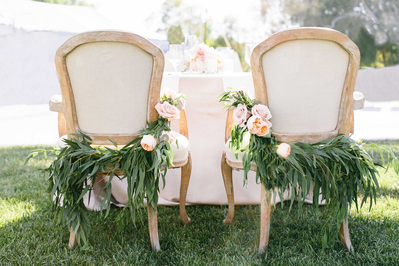 Sweetheart Table Chairs with Foliage
Photography: Callaway Gable
Read More:
http://www.insideweddings.com/weddings/alfresco-summer-wedding-with-lush-foliage-accents-in-california/805/ a couples chairs at their sweetheart table for their reception featuring lush greenery light flowers